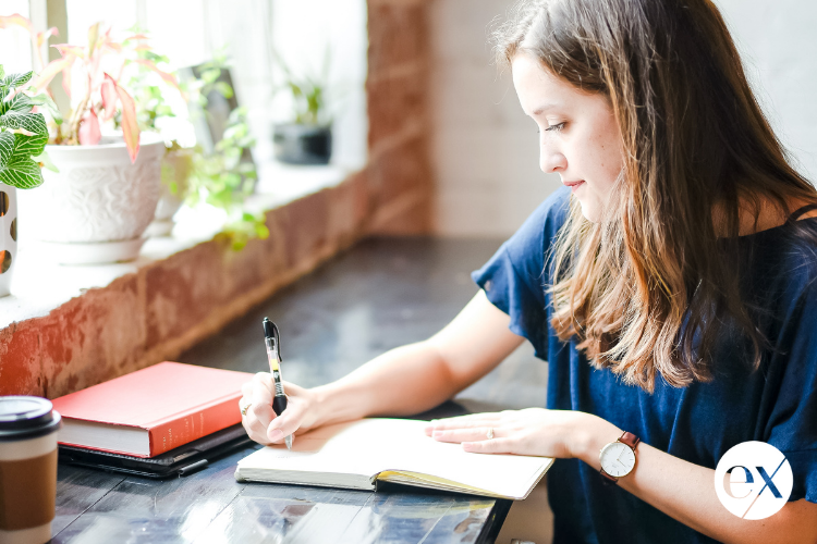 woman-writing-in-notebook-staying-focused-needs-after-divorce